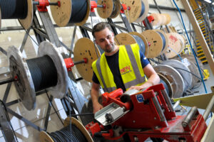 BEW Guildford employee in the warehouse managing machinery 